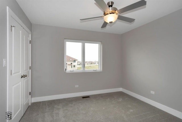 empty room featuring ceiling fan and light colored carpet