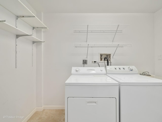 clothes washing area featuring light tile patterned floors and independent washer and dryer