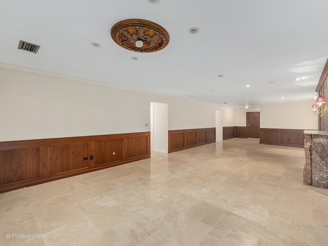 unfurnished living room with wood walls and crown molding