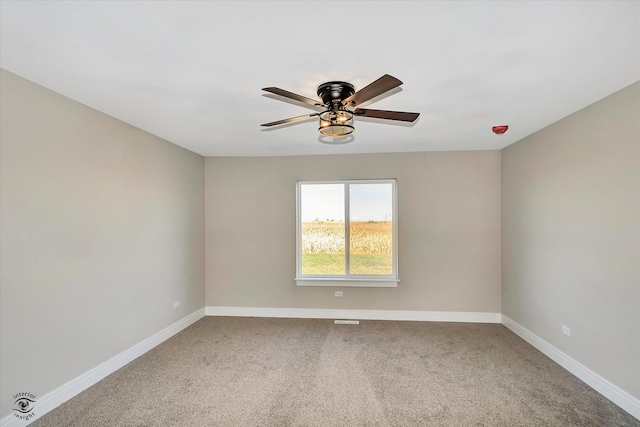 carpeted spare room featuring ceiling fan