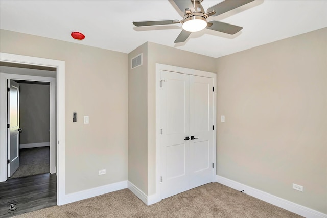 unfurnished bedroom featuring carpet floors, a closet, and ceiling fan