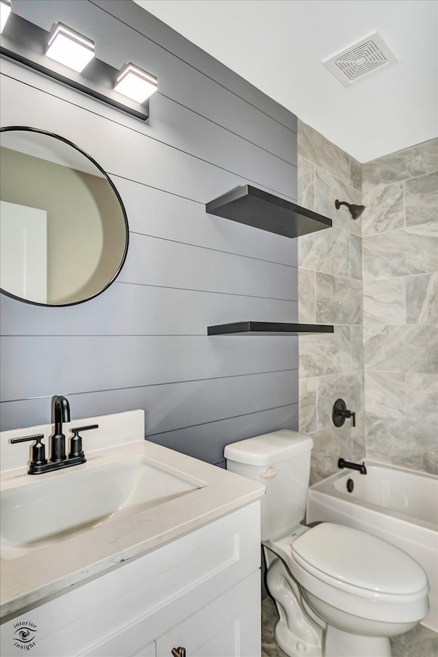 full bathroom with vanity, tiled shower / bath combo, toilet, and wood walls