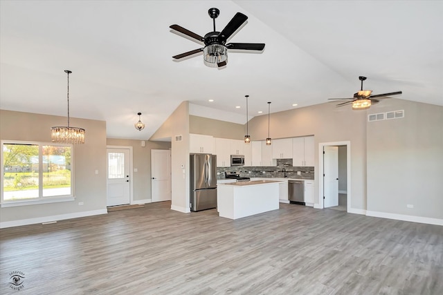 kitchen featuring white cabinetry, stainless steel appliances, light wood-type flooring, and a kitchen island