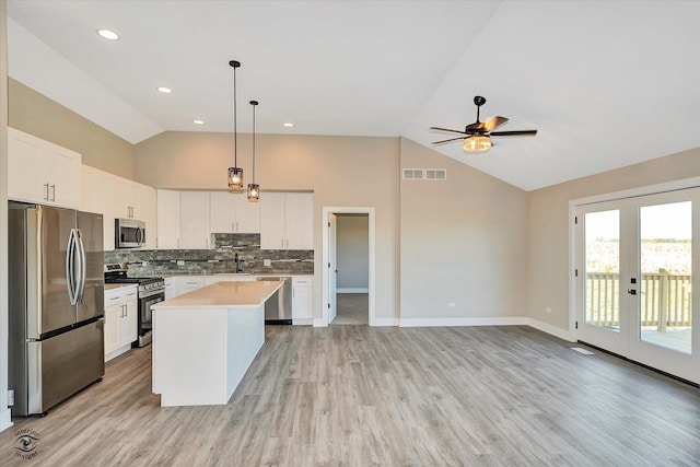 kitchen with a center island, white cabinets, stainless steel appliances, and light wood-type flooring