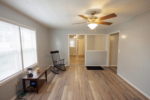 sitting room featuring ceiling fan, ornamental molding, and light hardwood / wood-style floors