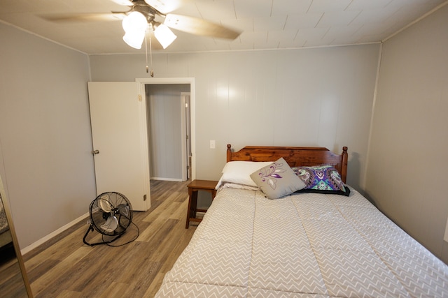 bedroom with ornamental molding, ceiling fan, and hardwood / wood-style flooring