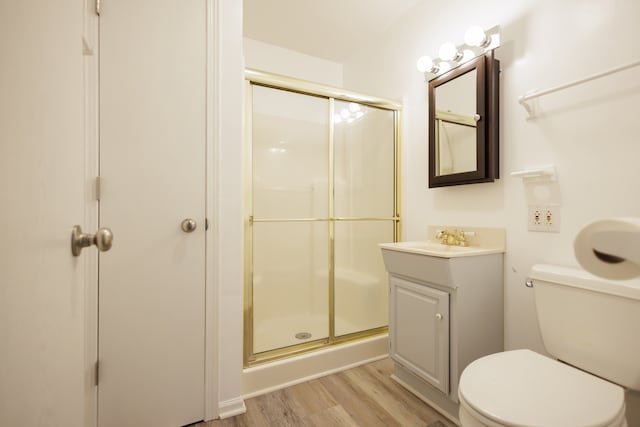 bathroom featuring vanity, hardwood / wood-style floors, toilet, and a shower with door