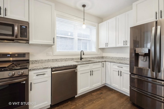 kitchen with sink, hanging light fixtures, dark hardwood / wood-style floors, white cabinets, and appliances with stainless steel finishes