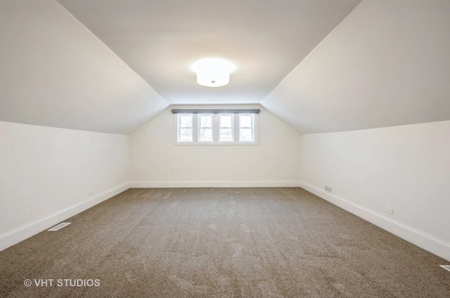 additional living space with carpet flooring and lofted ceiling