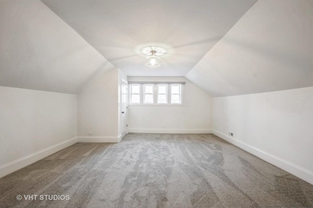 additional living space with carpet floors and vaulted ceiling