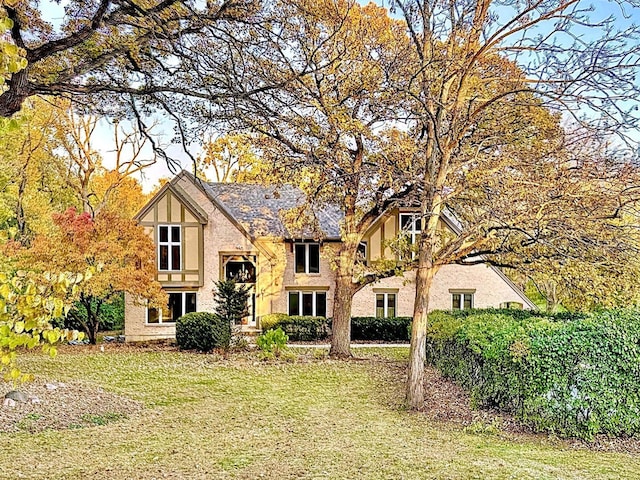 english style home with a front lawn