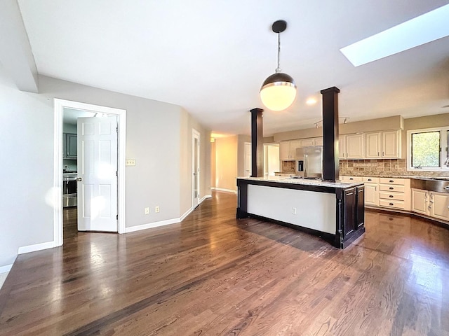 kitchen with stainless steel refrigerator with ice dispenser, a center island, pendant lighting, and dark hardwood / wood-style flooring