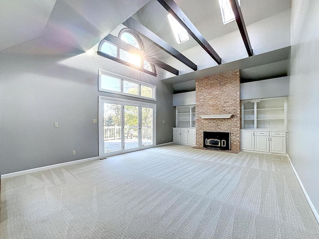 unfurnished living room featuring carpet floors, high vaulted ceiling, built in shelves, and a brick fireplace