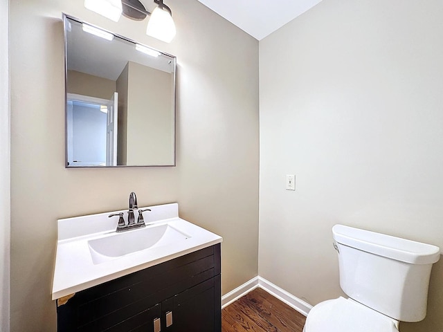 bathroom with vanity, toilet, and wood-type flooring