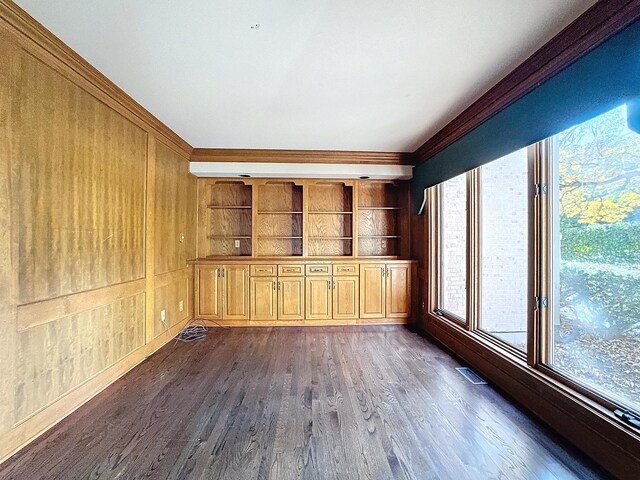 unfurnished living room with dark hardwood / wood-style floors and built in shelves