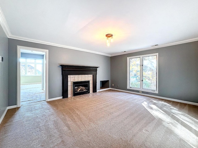 unfurnished living room featuring crown molding, a wealth of natural light, a tile fireplace, and light colored carpet