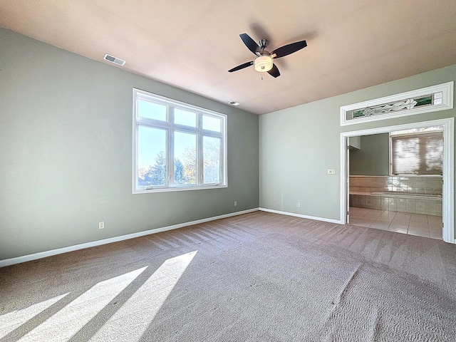 carpeted spare room featuring ceiling fan