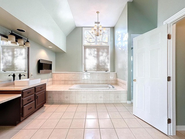 bathroom featuring lofted ceiling, tile patterned floors, a relaxing tiled tub, an inviting chandelier, and vanity