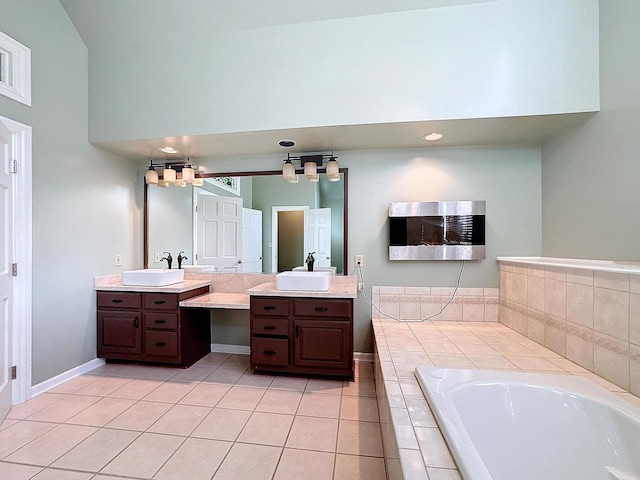 bathroom featuring vanity, lofted ceiling, tiled bath, and tile patterned flooring