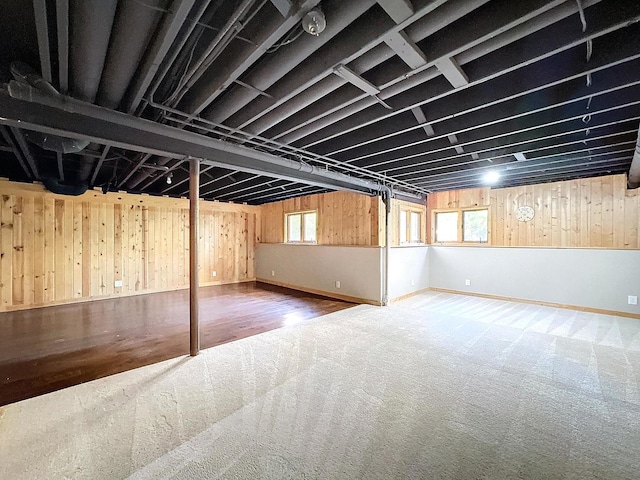 basement with wooden walls and wood-type flooring