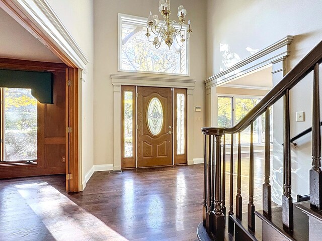 foyer entrance featuring a chandelier, a high ceiling, and dark hardwood / wood-style flooring