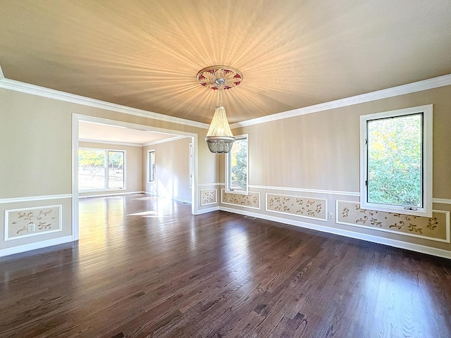 spare room featuring ornamental molding, dark hardwood / wood-style flooring, and a chandelier