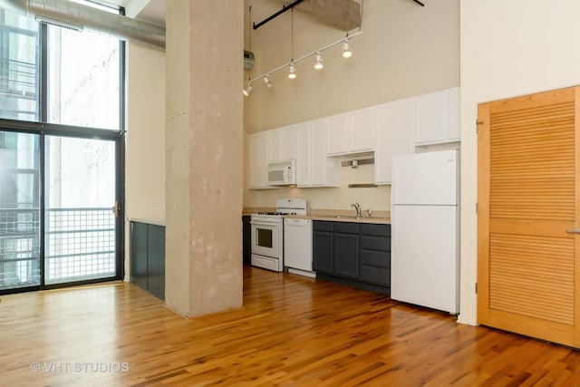 1645 W Ogden Ave Unit 434, Chicago, IL 60612 - kitchen with white appliances, a high ceiling, a sink, light wood-type flooring, and plenty of natural light