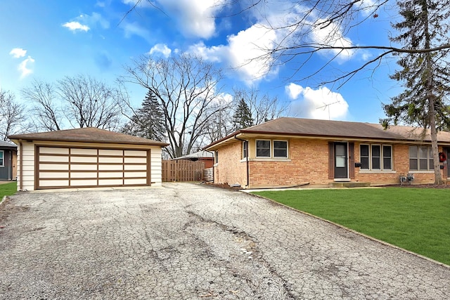 ranch-style house featuring a garage, fence, an outdoor structure, a front lawn, and brick siding