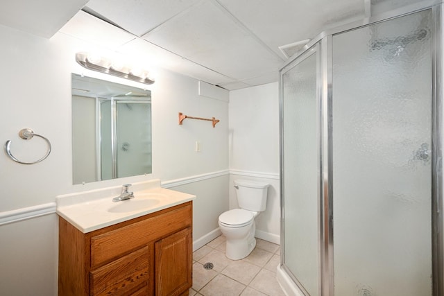 bathroom featuring vanity, a stall shower, tile patterned flooring, and toilet