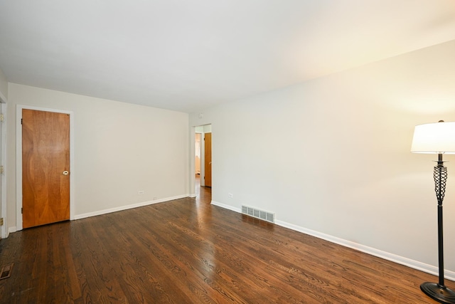 spare room featuring dark wood-style floors, baseboards, and visible vents