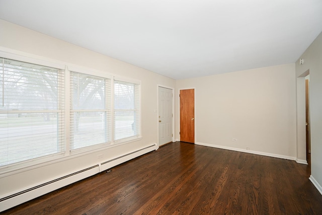 empty room with a baseboard heating unit, dark wood-style floors, and baseboards