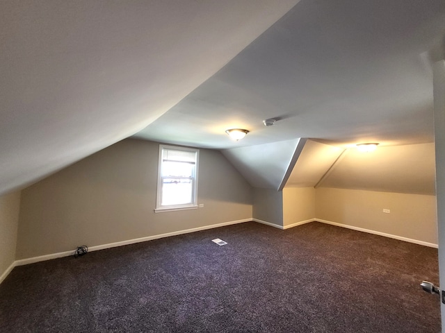 bonus room featuring dark carpet and vaulted ceiling