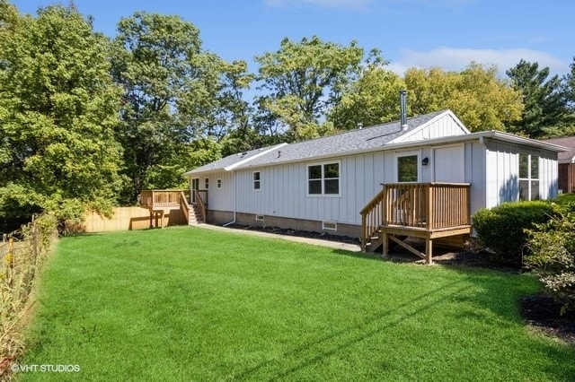 rear view of house featuring a deck and a lawn