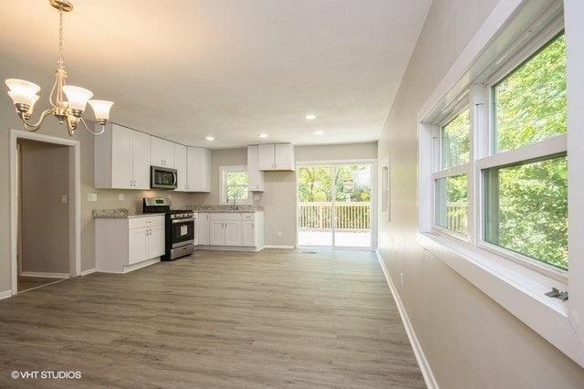 kitchen featuring a healthy amount of sunlight, light hardwood / wood-style floors, white cabinetry, and stainless steel appliances