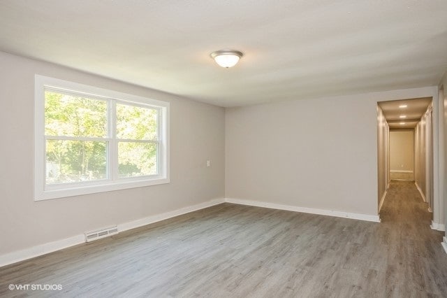 unfurnished room with hardwood / wood-style flooring