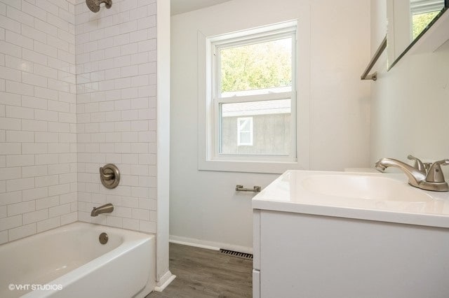 bathroom featuring tiled shower / bath combo, vanity, and hardwood / wood-style flooring