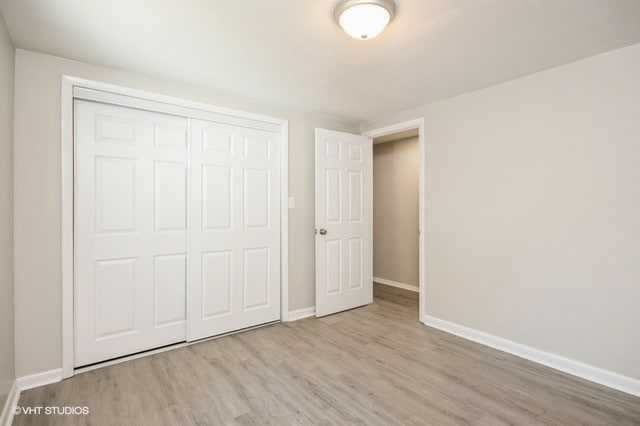 unfurnished bedroom featuring light hardwood / wood-style flooring and a closet