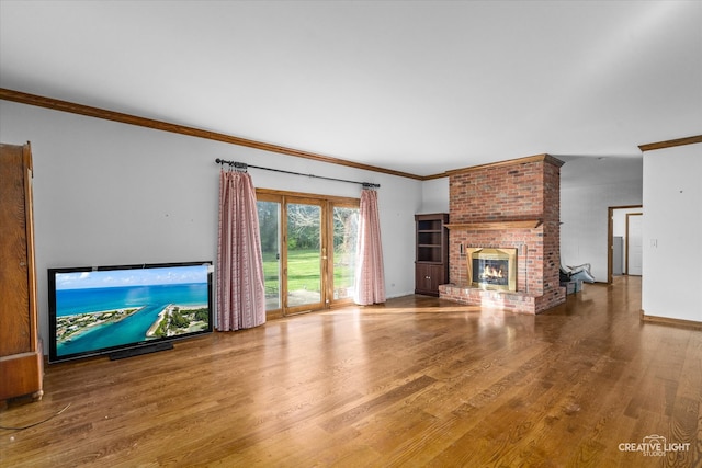 unfurnished living room with hardwood / wood-style flooring, a brick fireplace, and ornamental molding