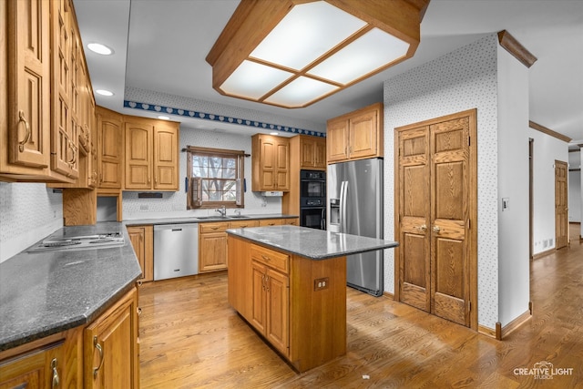 kitchen featuring a center island, crown molding, sink, light hardwood / wood-style flooring, and stainless steel appliances