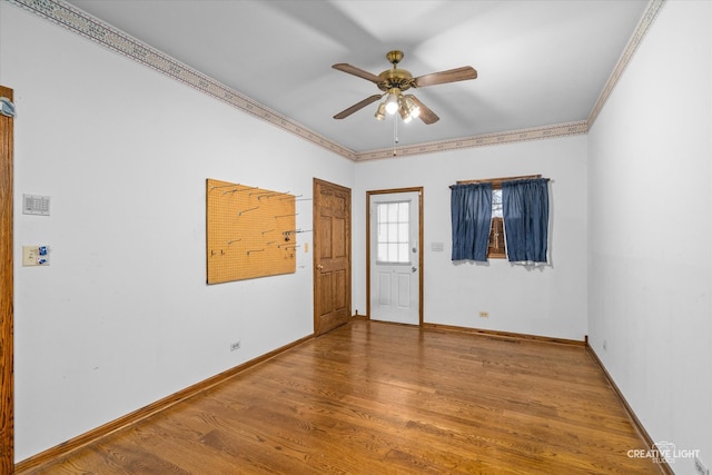 spare room featuring crown molding, hardwood / wood-style floors, and ceiling fan