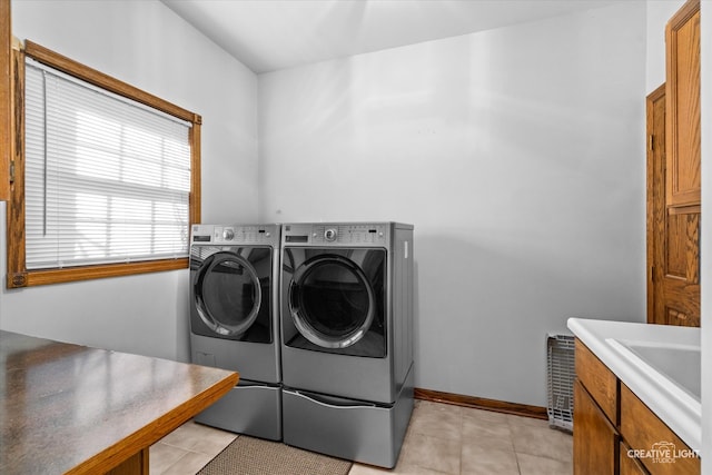 laundry area featuring sink, light tile patterned floors, cabinets, and independent washer and dryer