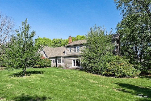 rear view of house featuring a yard