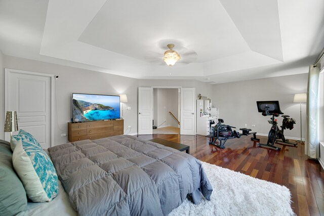 bedroom featuring wood-type flooring, a tray ceiling, and ceiling fan