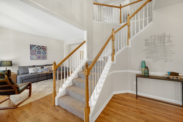 stairway featuring hardwood / wood-style flooring and ornate columns