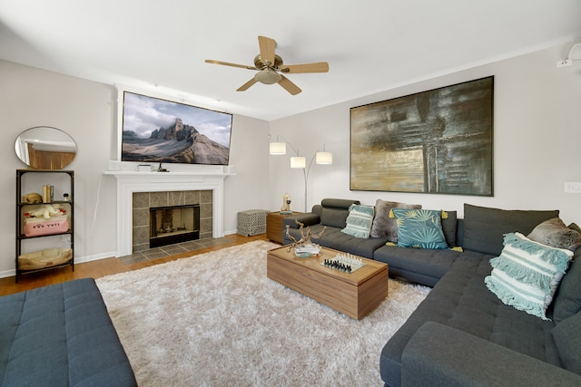 living room with wood-type flooring, a fireplace, and ceiling fan