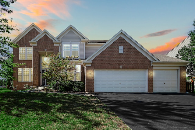 view of front of property with a garage and a lawn