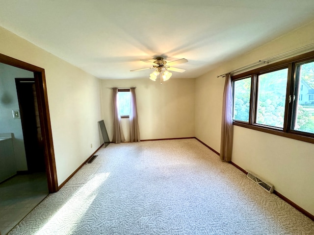 spare room with ceiling fan and light colored carpet