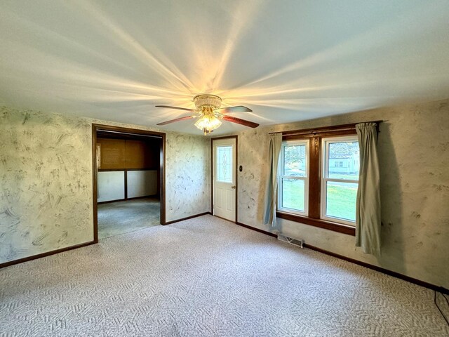 unfurnished room featuring ceiling fan and light carpet