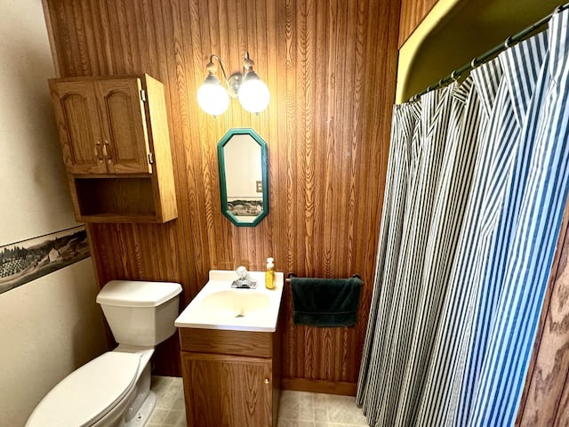 bathroom featuring a shower with curtain, wooden walls, toilet, and vanity