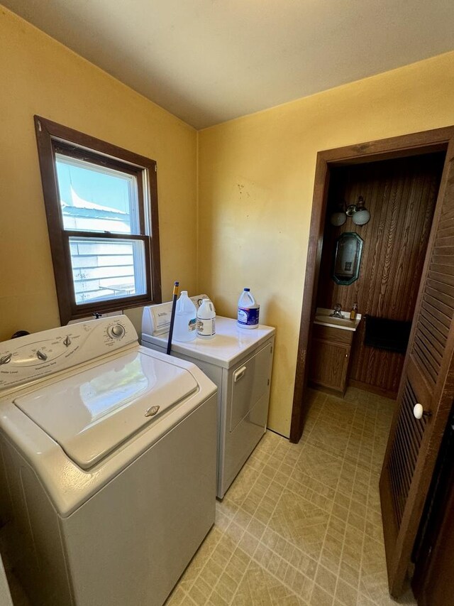 laundry room with laundry area, a sink, and separate washer and dryer